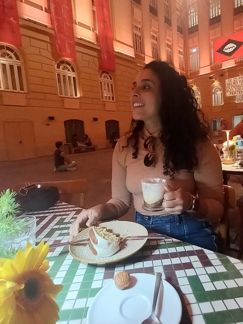 Vaneska Cavalcante conversando numa mesa de café, num salão histórico